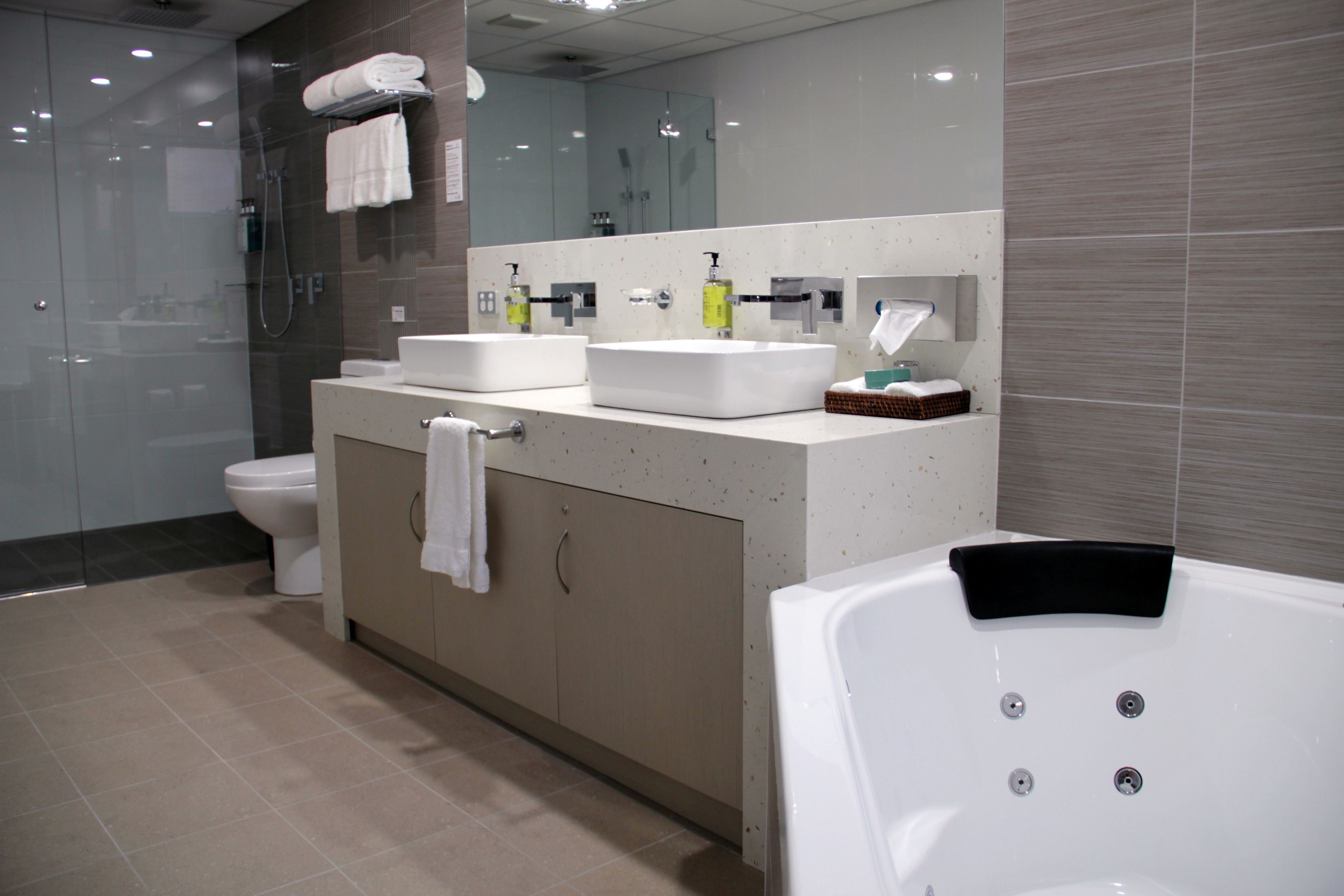 A modern bathroom with a glass-enclosed shower, a double sink vanity, and a standalone bathtub.