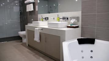 A modern bathroom with a glass-enclosed shower, a double sink vanity, and a standalone bathtub.