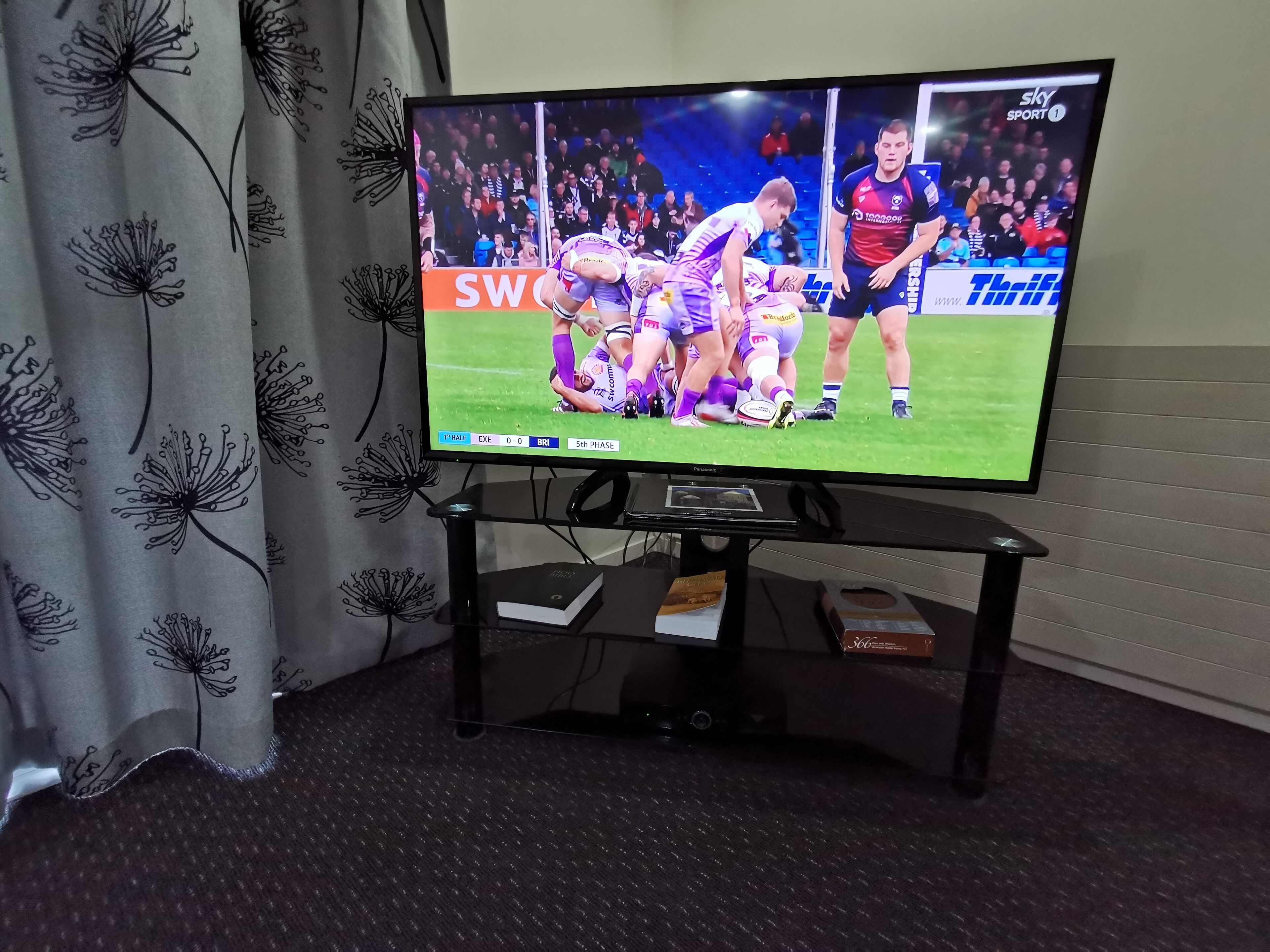 Ein Fernseher auf einem Standfuß zeigt eine Sportveranstaltung.