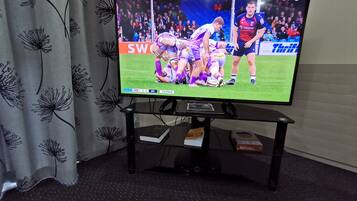 Ein Fernseher auf einem Standfuß zeigt eine Sportveranstaltung.