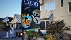 Une pancarte de Capri Rotura NZ fait la publicité d’une piscine thermale chauffée par énergie géothermique, présente dans chaque chambre.