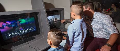 A family playing a video game at a gaming station.
