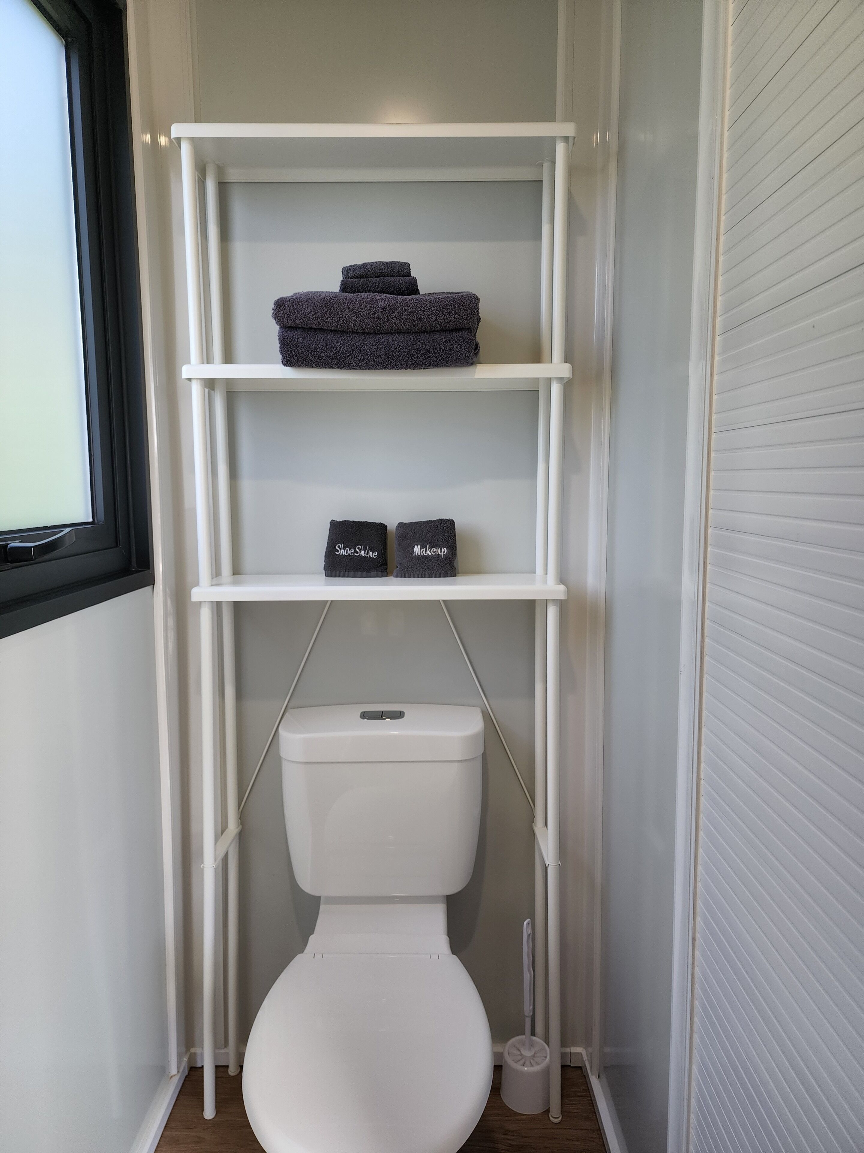 A white toilet with a white toilet paper holder and a white bidet.
