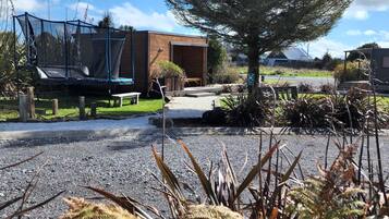 Guests can enjoy a tranquil outdoor space with a pathway leading to the building entrance, surrounded by lush landscaping and a shaded area.
