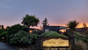 Une enseigne pour le Plateau Lodge, avec un bord en pierre et un panneau en bois.