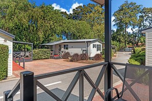 A mobile home with a covered porch, a paved driveway, and a landscaped garden. - Discovery Parks - Perth Airport (Forrestfield)