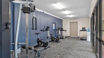 Un gimnàs amb màquines cardiovasculars, aparells de musculació i una zona de beufit.
