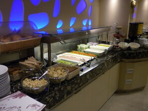 A buffet with various food items and containers.