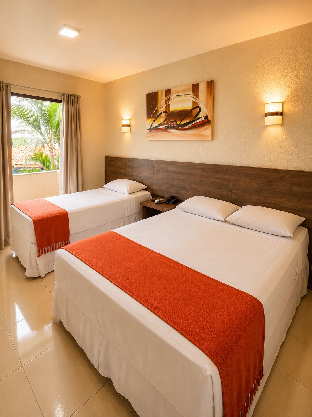 Habitación de hotel con dos camas, una mesita de noche, un teléfono y un cuadro en la pared.