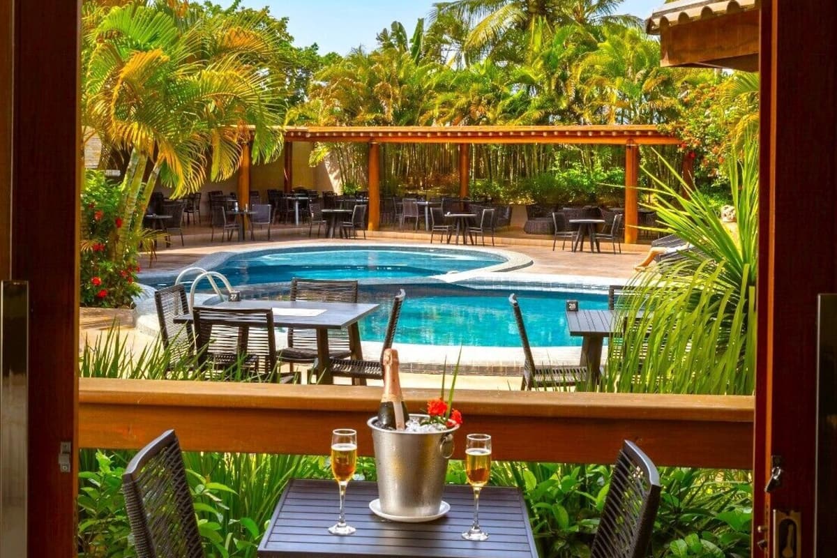 A room with a view of a pool and outdoor seating area.