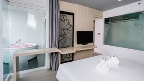 A modern hotel room with a large bed, a TV, a glass-enclosed shower, and a wooden desk. - SLEEP WITH ME HOTEL design hotel @ patong (Patong)