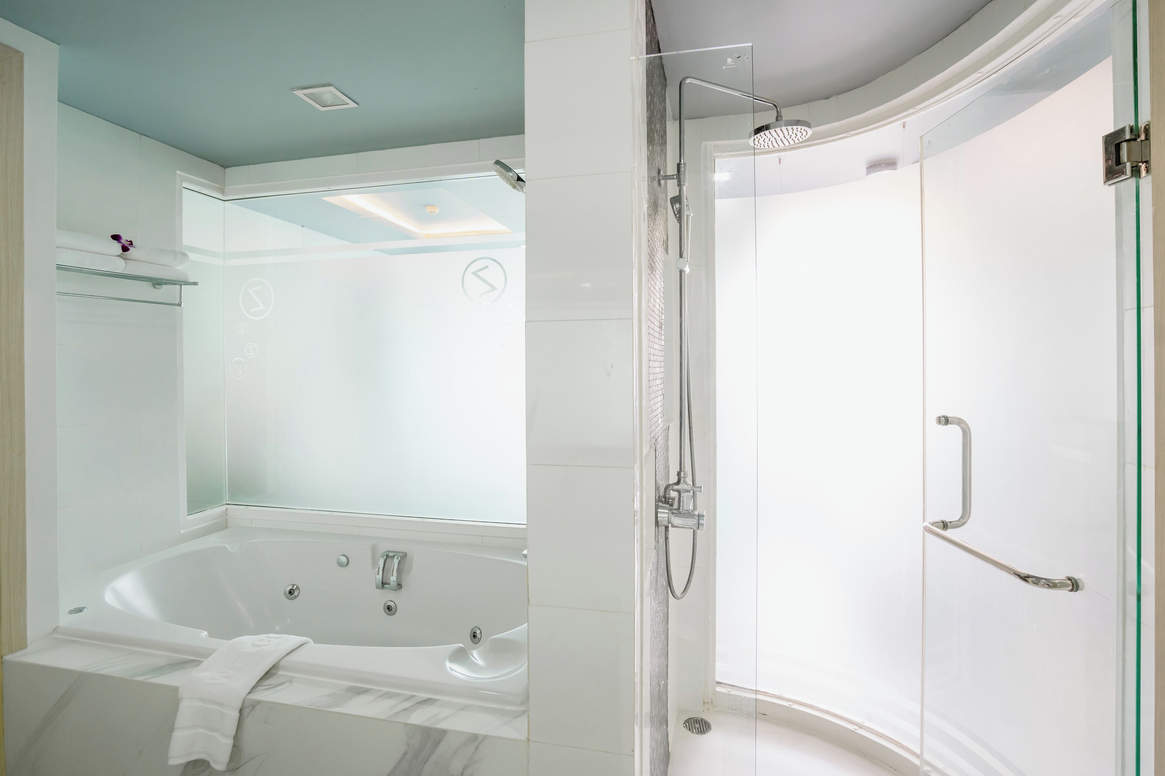 Une salle de bain moderne dotée d’une douche à parois de verre, d’une baignoire sur pieds et d’une porte de douche en verre.