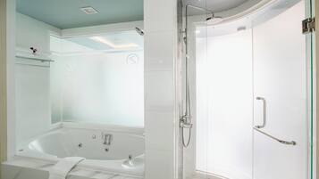 Une salle de bain moderne dotée d’une douche à parois de verre, d’une baignoire sur pieds et d’une porte de douche en verre.
