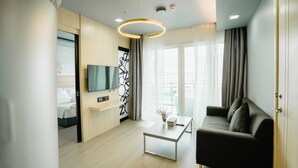 A modern living room with a sofa, coffee table, and a flat-screen TV. - SLEEP WITH ME HOTEL design hotel @ patong (Patong)