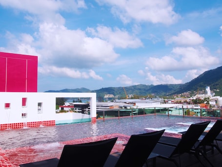 Una piscina al aire libre, sillones reclinables de piscina