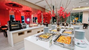 A buffet area with various food stations, a coffee machine, and a decorative vase with branches. - SLEEP WITH ME HOTEL design hotel @ patong (Patong)