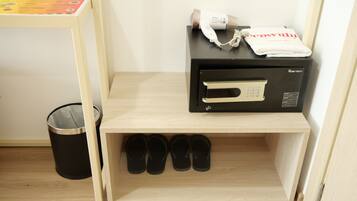 Une étagère en bois avec un four à micro-ondes, une paire de chaussons et une poubelle.