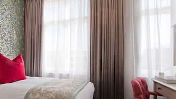 Una habitación de hotel con una cama, un escritorio y una silla.