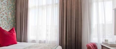 Une chambre d’hôtel avec un lit, un bureau et une chaise.