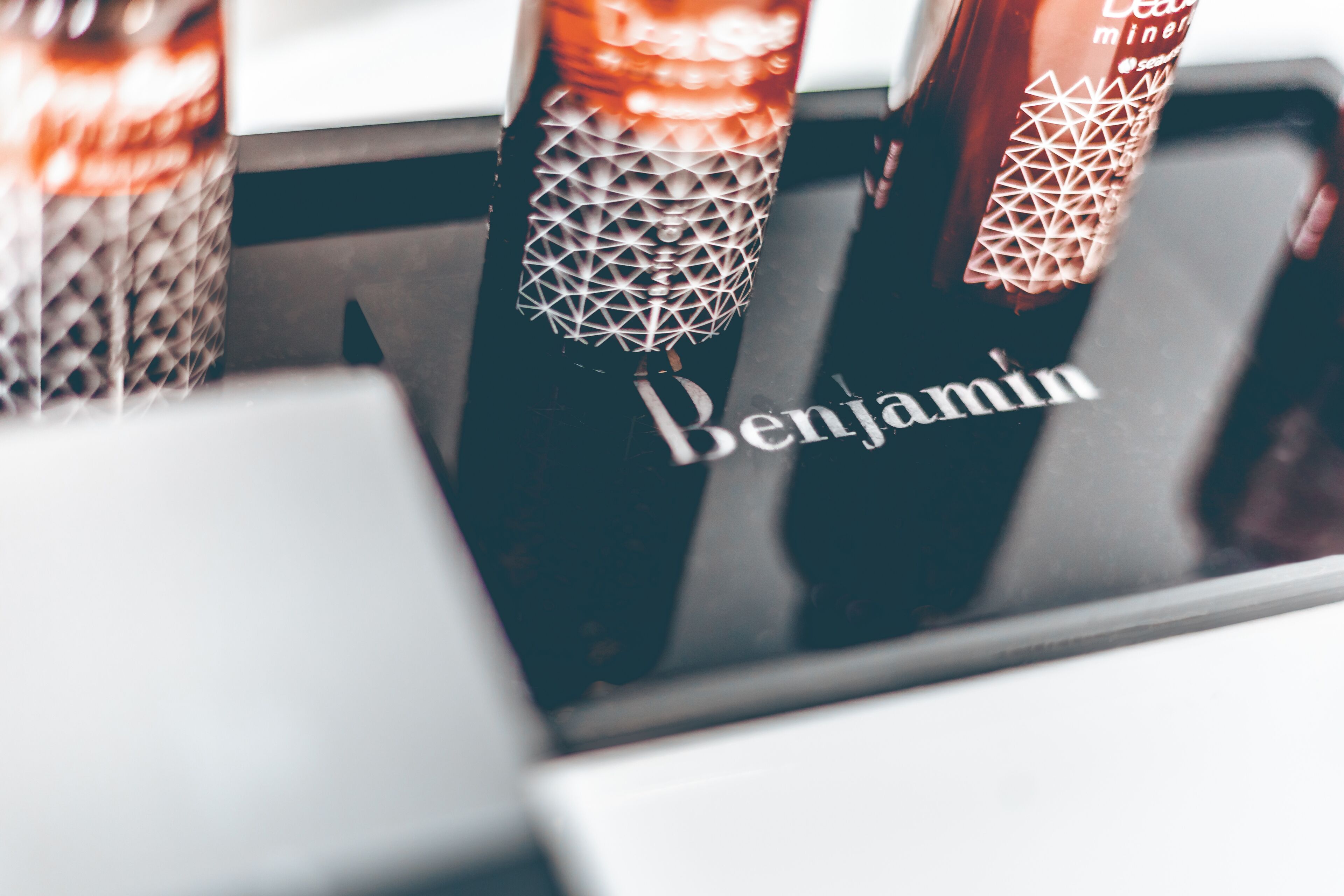 A close-up of a bottle with a geometric pattern and the word "Benjamin" on it.