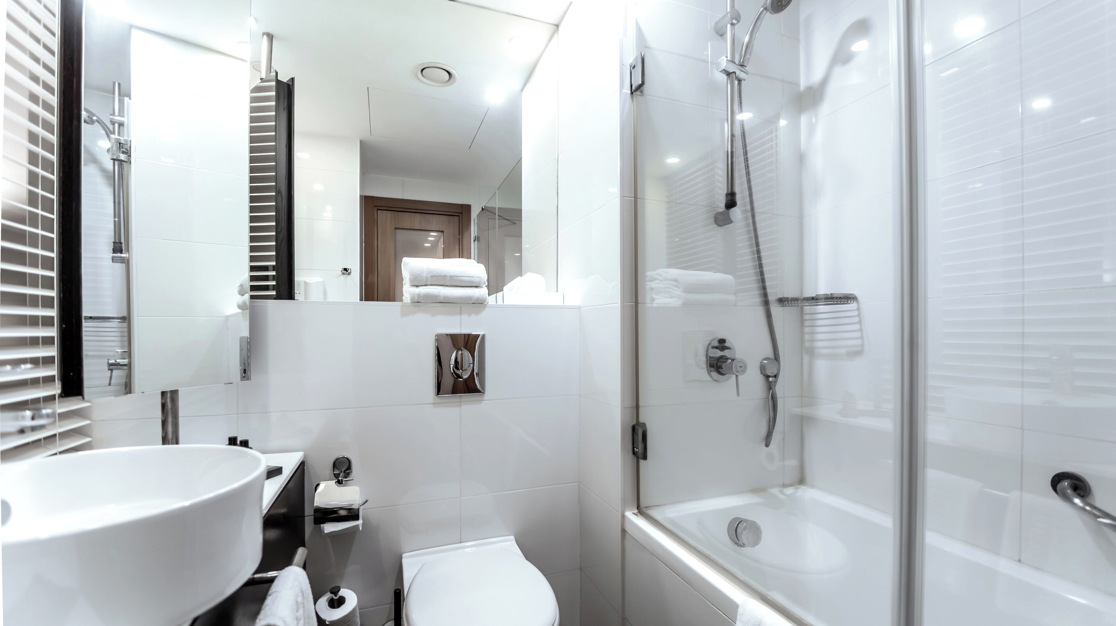 Un baño moderno con un lavamanos grande, inodoro y ducha a ras de suelo.