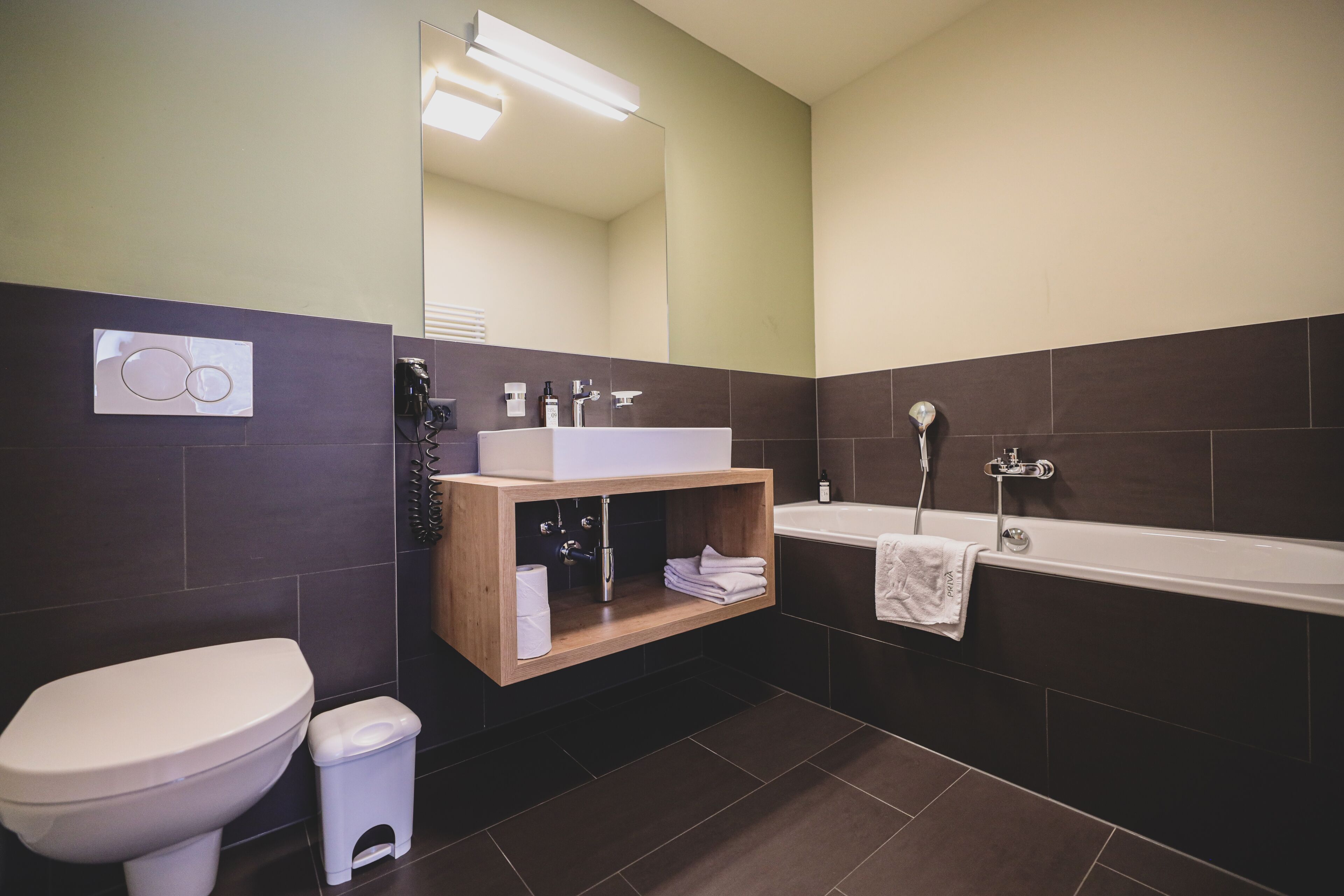 Un baño moderno con inodoro, lavamanos y bañera.