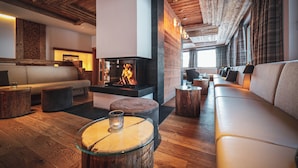 Una sala de estar moderna con chimenea, suelo de madera y un sofá de cuero.