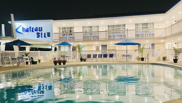 Ein Hotel mit Schwimmbad, Außenbereich und einem Schild mit der Aufschrift 'Chateau Bleu'.