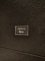 Superficie de cuero negro con una etiqueta que dice "ARMANI Roca".