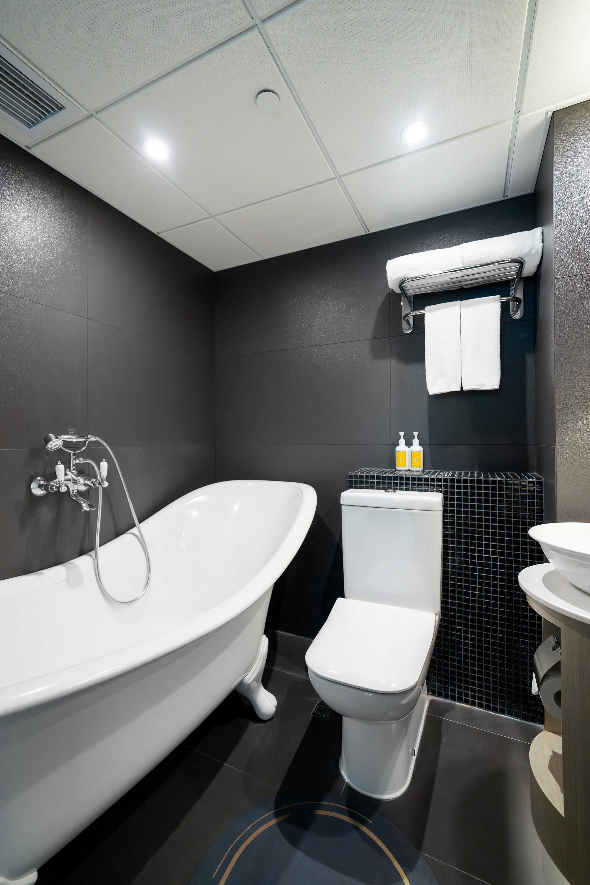 signature suite | bathroom | designer toiletries, hair dryer, slippers, towels