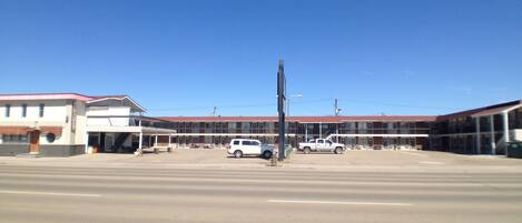 A building with a flat roof and a large parking lot.