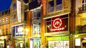 Un edificio con un llamativo letrero que dice 'Hotel', una calle empedrada y un hidrante.
