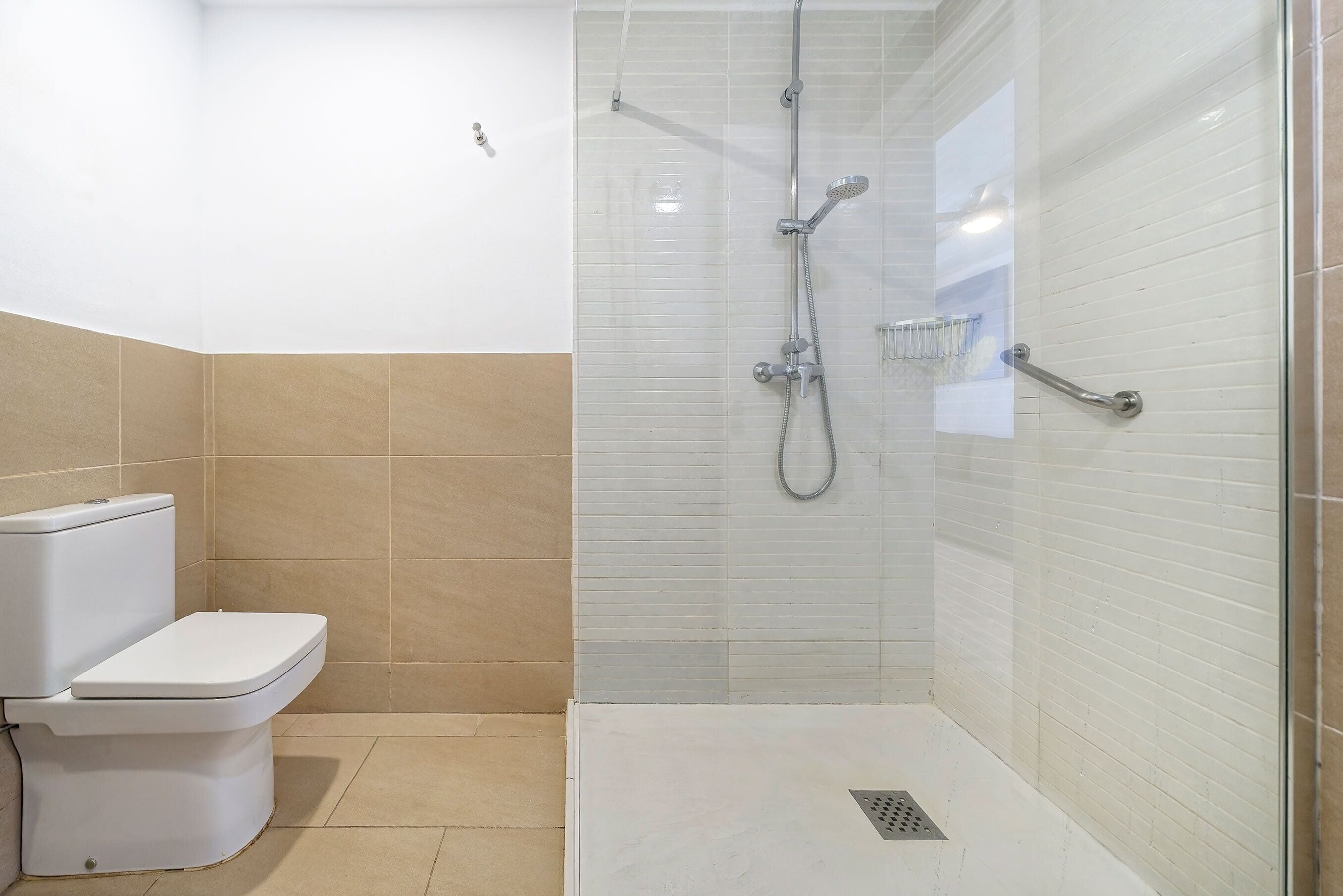 Ein Badezimmer mit Toilette, Duschkabine und Glastür.