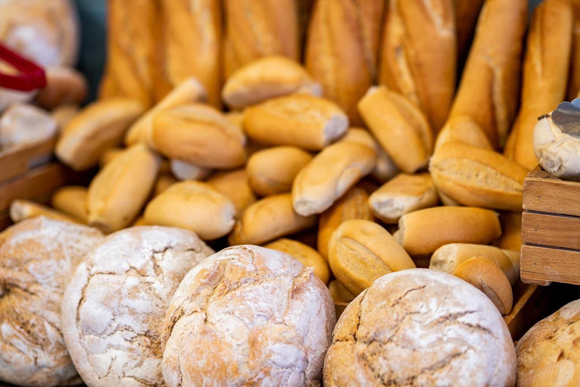 A variety of bread loaves displayed in wooden crates.