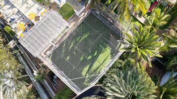 Luchtbeeld van een hotel met een groot buitengebied, inclusief een zwembad en omliggende palmbomen.