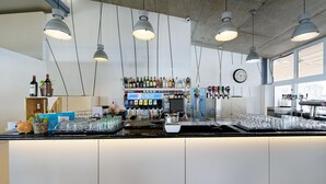 Zona de bar con refrigerador de Pepsi, varias botellas y vasos.