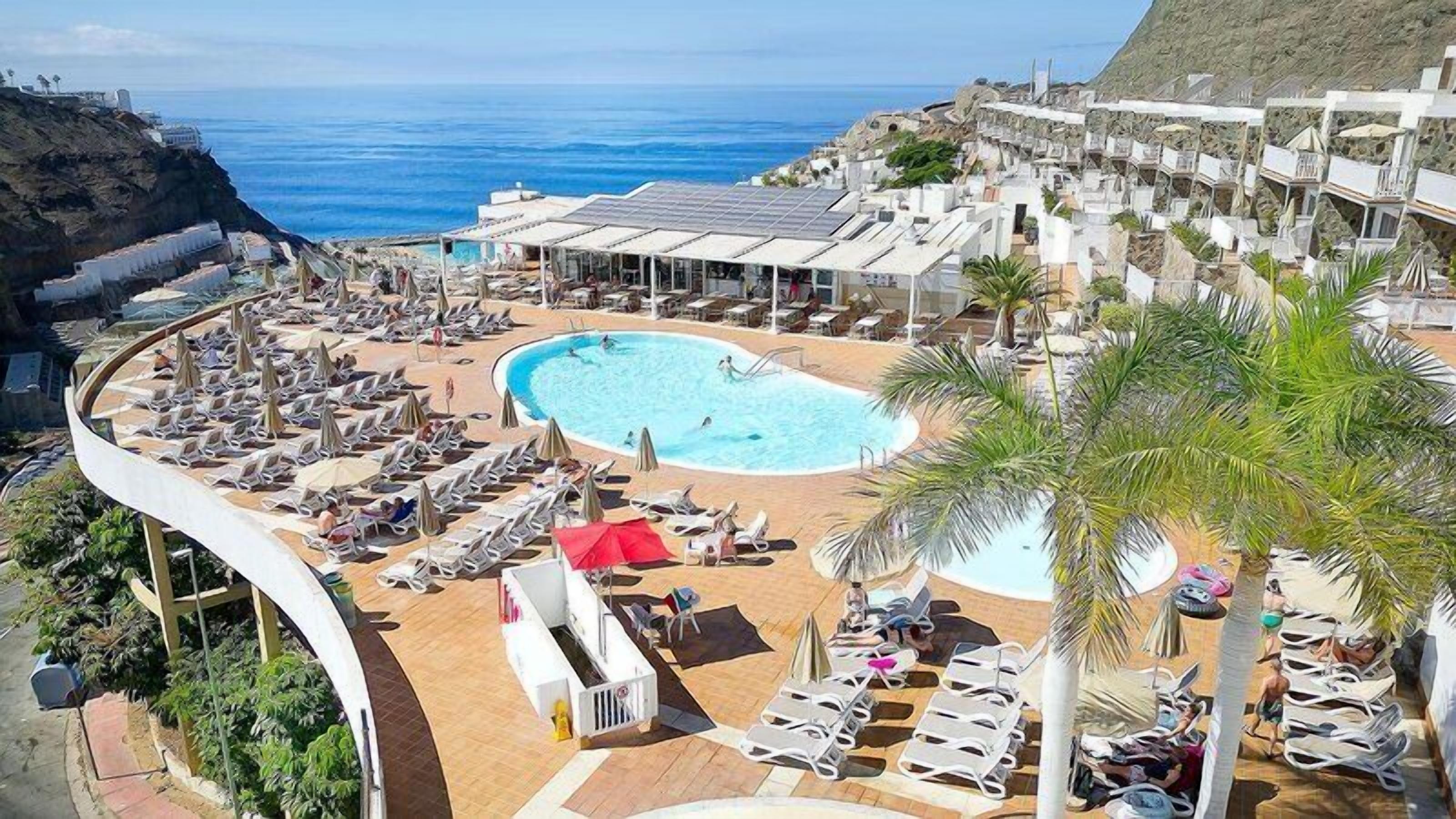 Piscine extérieure, parasols de plage, chaises longues