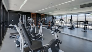 A modern gym with various cardio and strength training equipment, large windows, and a clean, spacious layout. - Linx Galeão by Wish (Rio de Janeiro)
