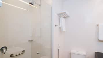 Un baño moderno con cabina de ducha de vidrio, inodoro y toallero.