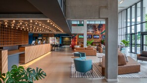A spacious lobby with a reception desk, seating area, and large windows. - Linx Galeão by Wish (Rio de Janeiro)