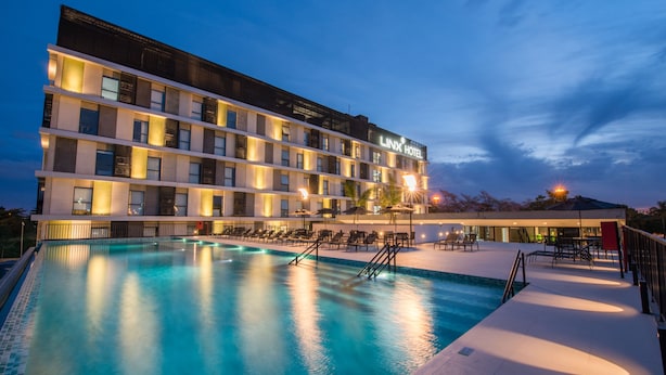 A hotel with a swimming pool, multiple floors, and outdoor seating areas. - Linx Galeão by Wish (Rio de Janeiro)