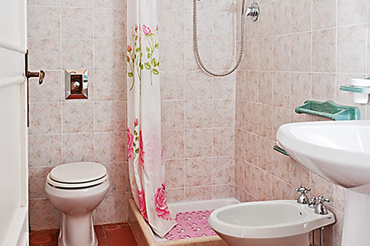 Une salle de bain équipée d’une douche, de toilettes, d’un bidet et d’un lavabo.