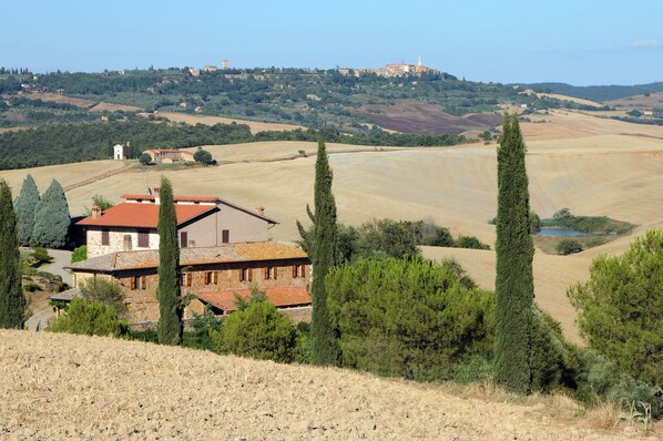 A rural house with a red roof, surrounded by trees and fields. - Agriturismo La Buca di Bellugi (San Quirico d'Orcia)