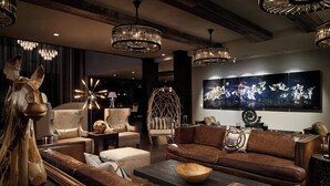 Un salon moderne avec des canapés en cuir, une grande peinture abstraite et une sculpture originale représentant un cheval.