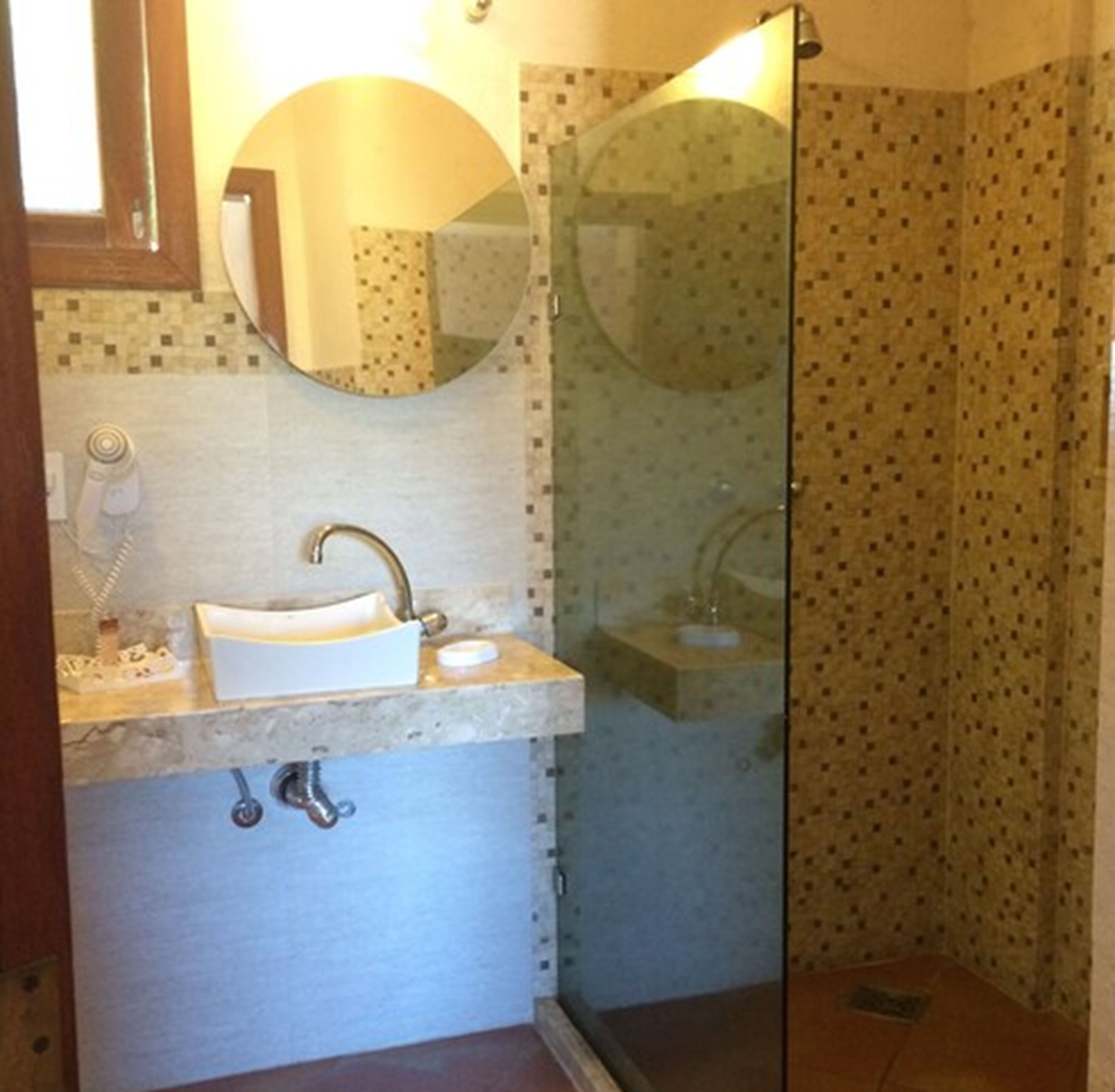 Un bagno con lavandino, specchio e doccia.