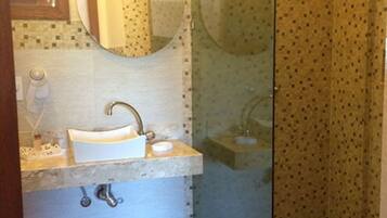 Un bagno con lavandino, specchio e doccia.