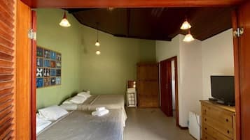 A room with two beds, a television, and a wooden cabinet.