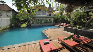 Una piscina al aire libre, sombrillas, tumbonas