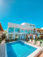Um edifício moderno de dois andares com uma piscina em frente.