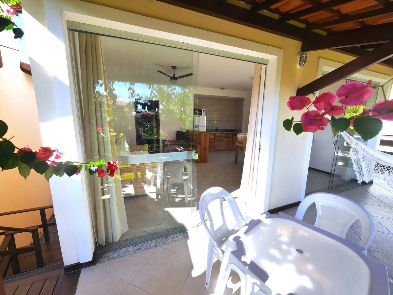 Pátio externo com porta de vidro que dá para uma cozinha.